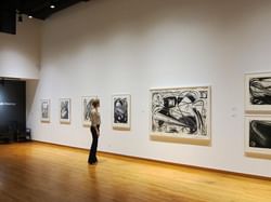A lady looking at art in Thames Art Gallery near Retro Suites