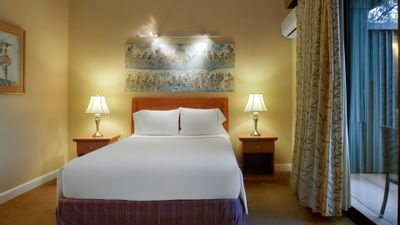 white bed in room with curtains