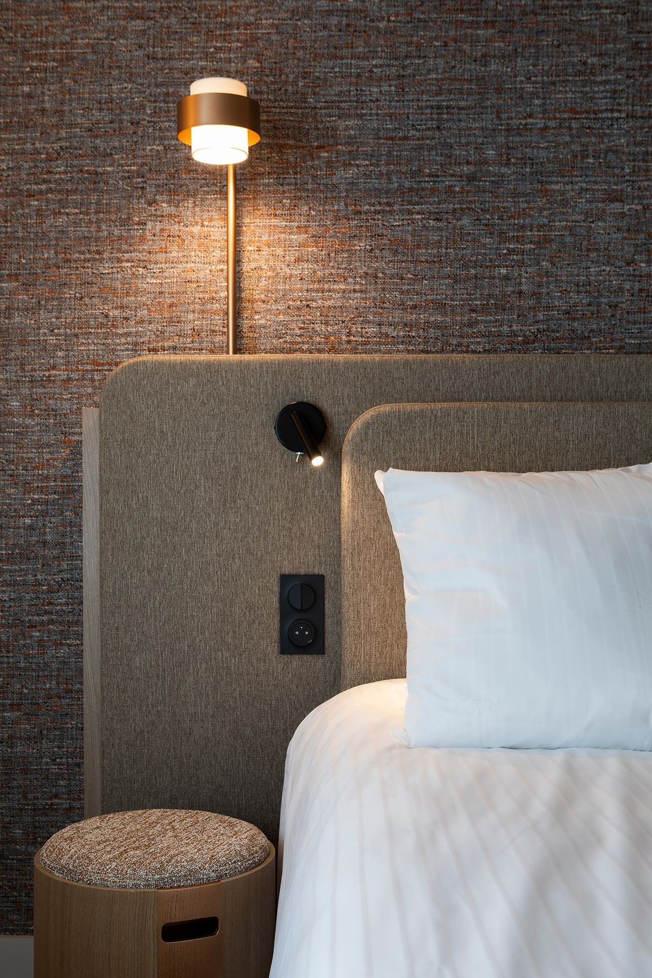 Gros plan d'un appuie-tête avec une lampe de chevet dans une chambre à l'Oceania Saint-Malo