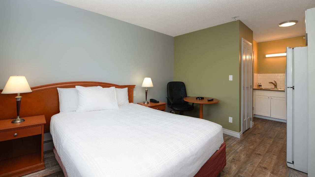 Guest room at Coast Red Deer Hotel with queen bed, desk and kitchenette