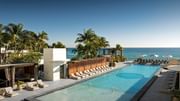 Luxe infinity pool with sweeping ocean views and poolside lounge chairs.
