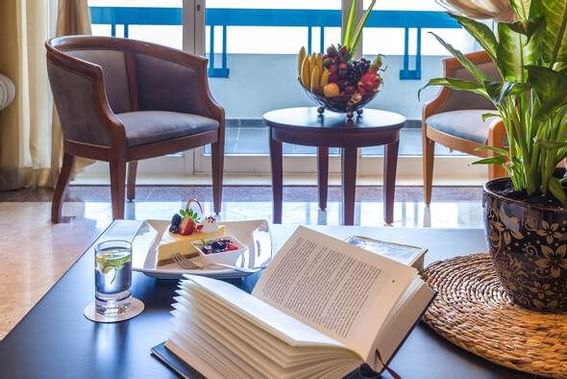 Opened book & Cheesecake slice on a table at Ajman Hotel