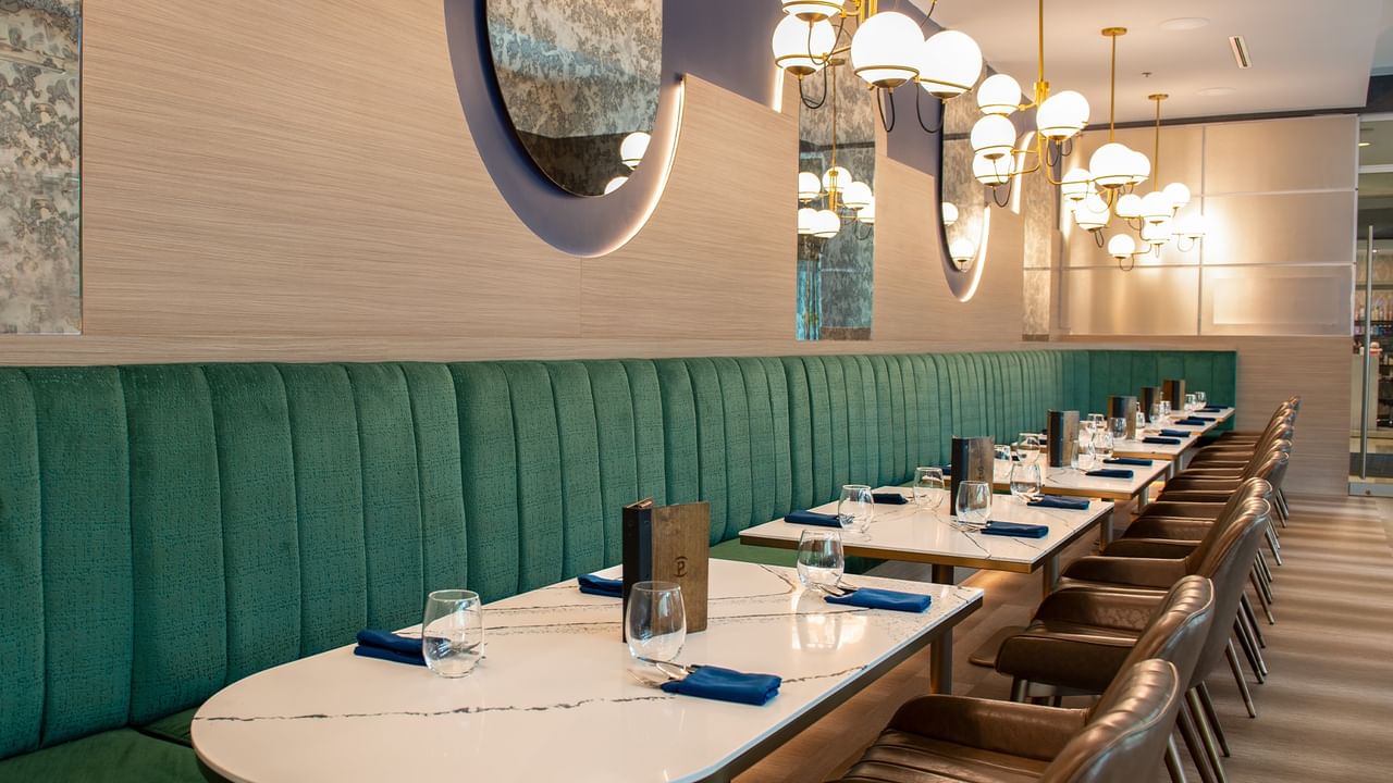 Modern restaurant interior with seating, tables, and elegant lighting.