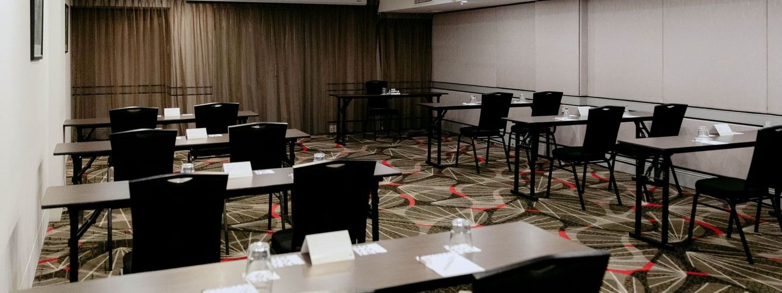 Elegantly arranged event tables and chairs in the Jarrah Room at Novotel Sydney Parramatta.