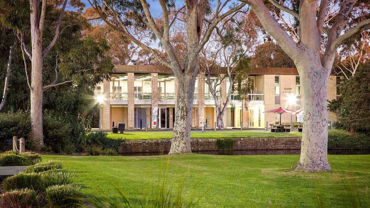Glenn College building with lush greenery and trees at La Trobe University.