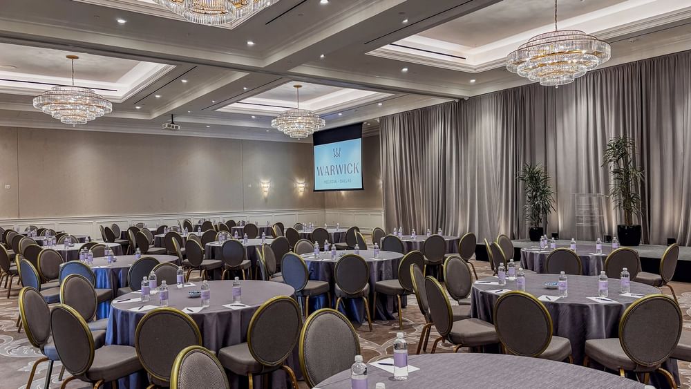 Turtle Creek Ballroom event room with tables and chairs at Warwick Melrose - Dallas.