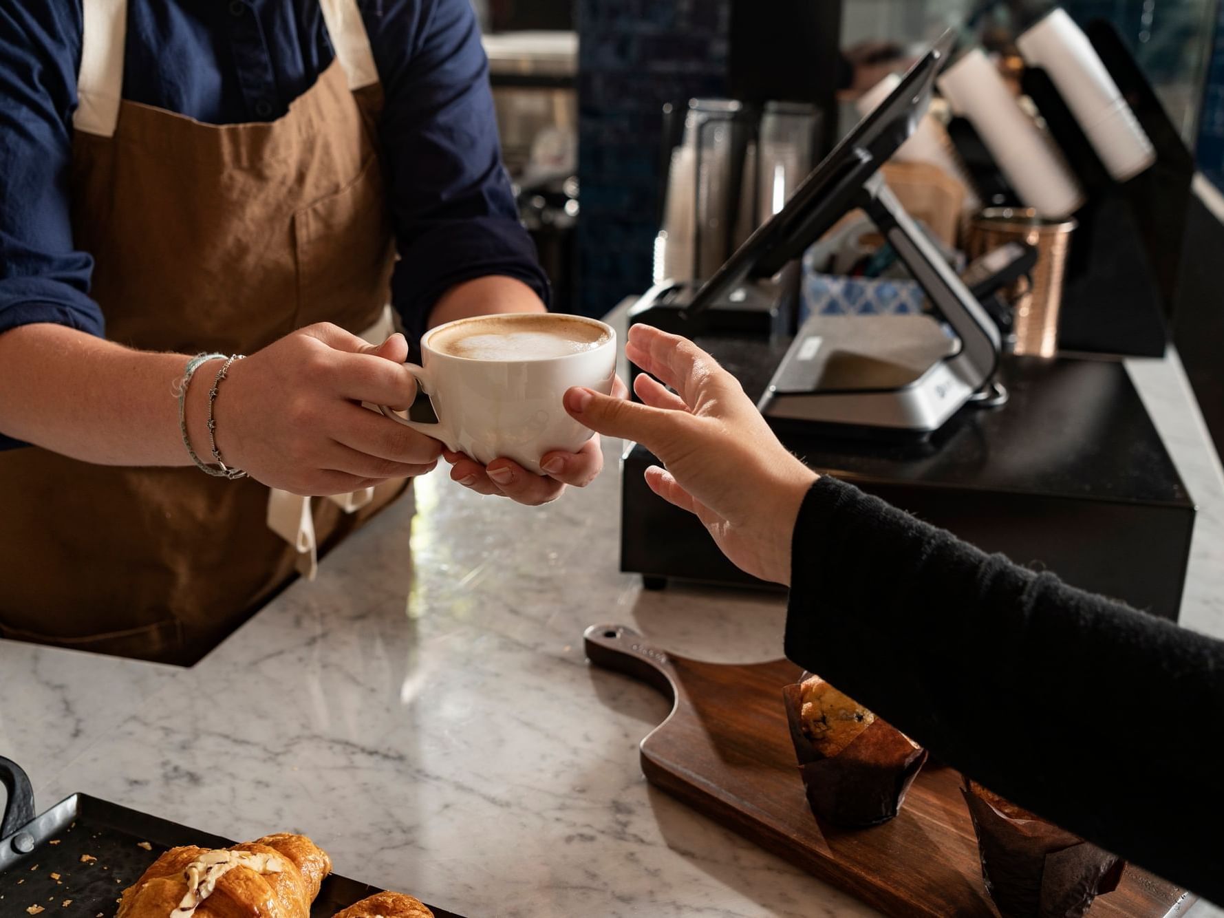 Handing over a cup of coffee in cafe of Hotel Saint Clair