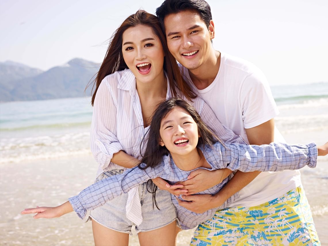 Happy Family of 3 At The Seaside