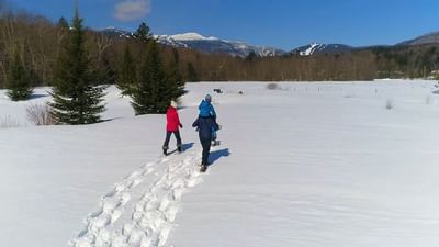 Three people walking on snow near Topnotch Stowe Resort