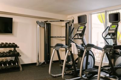 Hotel fitness center with treadmills, cable machine, and a rack of free weights at Kenmore Village Hotel, South Beach hotels