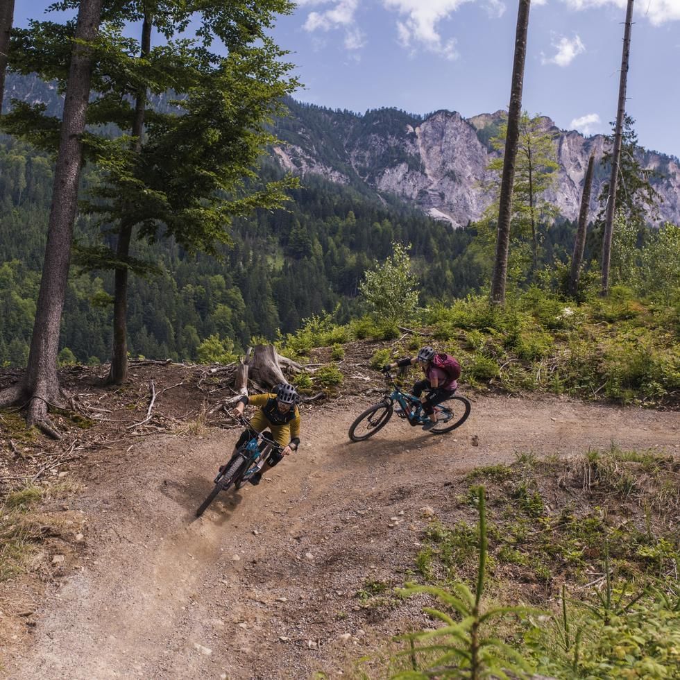 2 bikers riding on a trail on hills near Falkensteiner Hotels