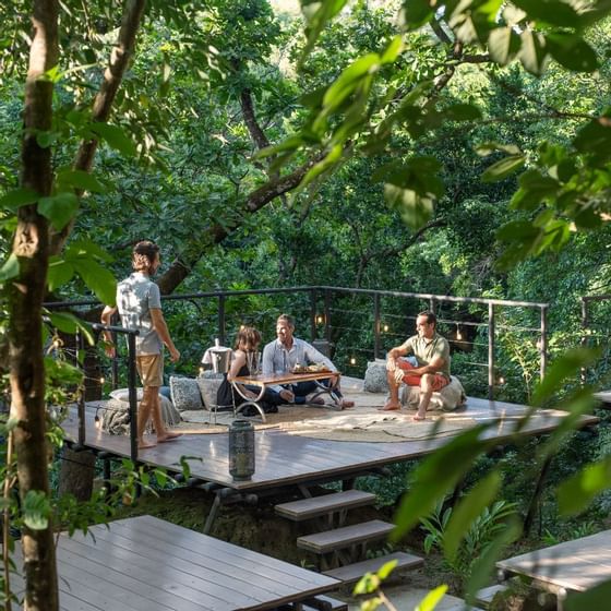 Friends lounging on the terrace overlooking the forest at Hotel Rio Perdido