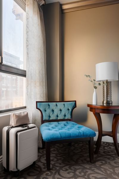 Cozy corner with a blue tufted chair & wooden table in Deluxe King Room at Hotel Bijou, featuring San Francisco accommodation