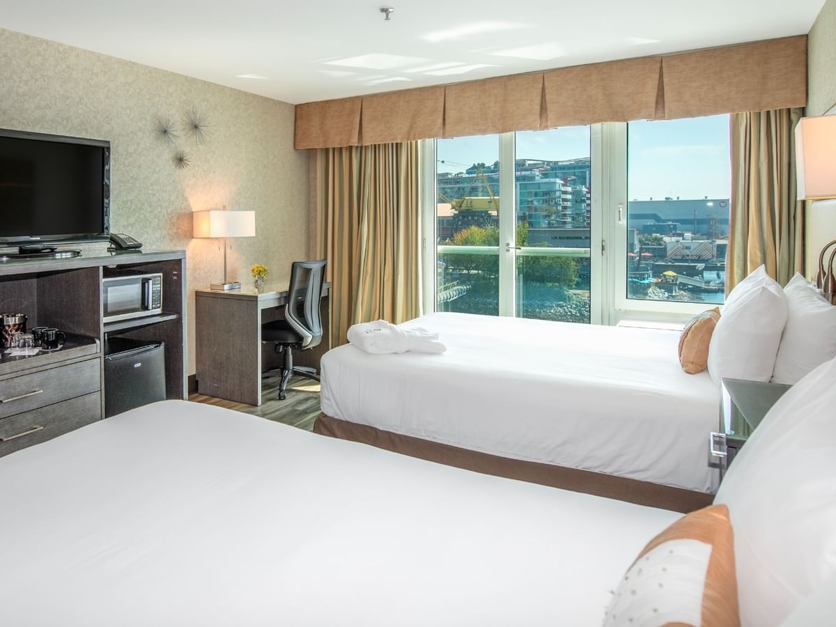Coast Premium Two Queens with Two beds, TV, desk, and window with city view in a hotel room at Coast Lonsdale Quay Hotel