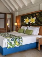 Large bed beside table lamp with plumeria floral artwork in Lagoon Bungalow at warwick le lagon-vanuatu