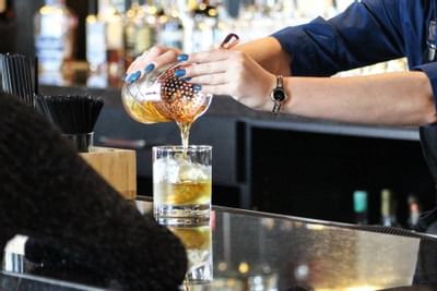 a bartender pouring a cocktail