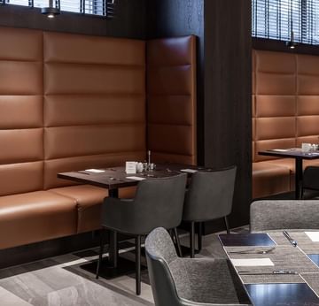 Essbereich mit Lederbank und Tischen im Frühstücksrestaurant des Titanic Comfort Kurfürstendamm