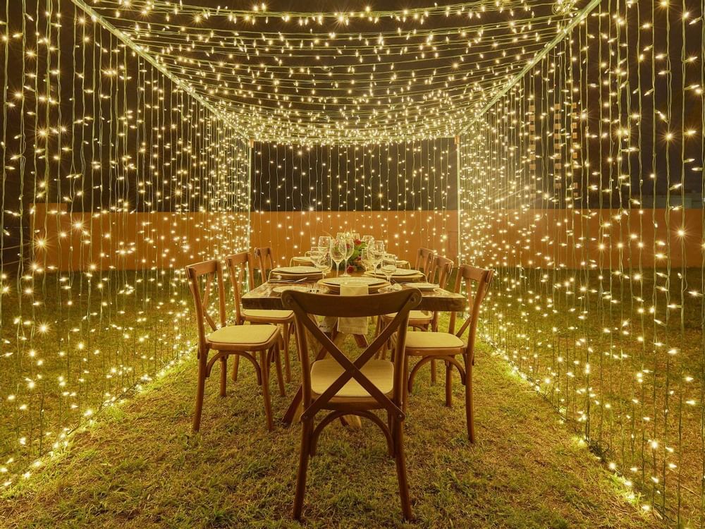 Dining table setup under light strips at Grand Fiesta Americana