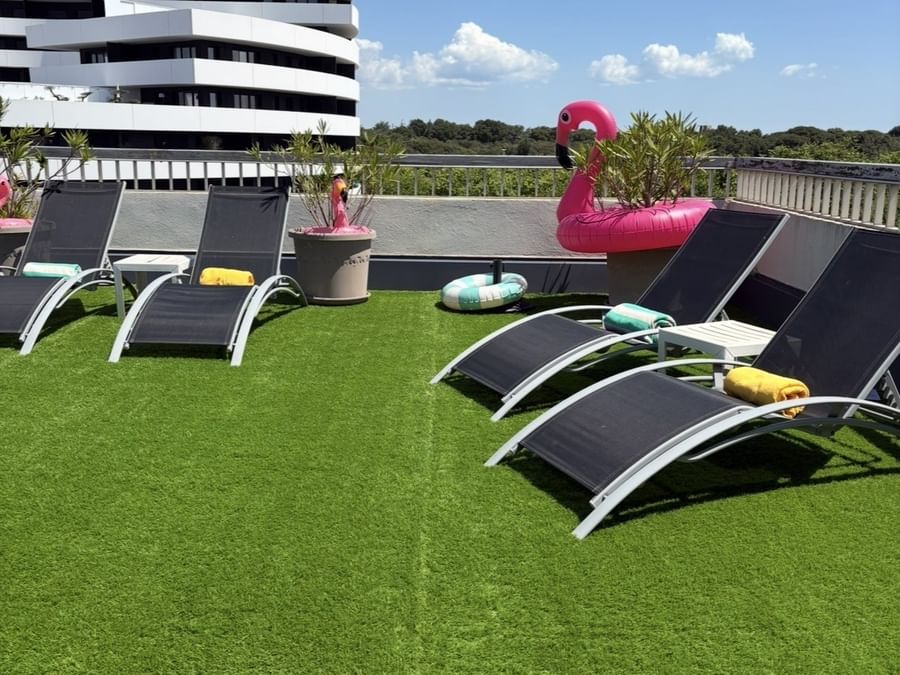 Loungers and artificial grass on a rooftop terrace at Hôtel Cap Maya in Agde.