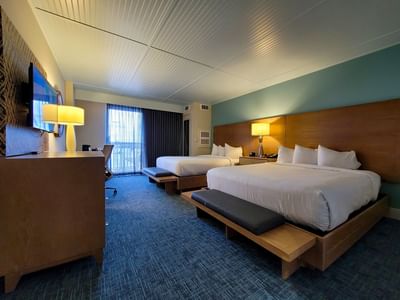 Standard Double Queen with Balcony at Margaritaville Resort Biloxi, featuring blue carpets and warm wooden accent furniture