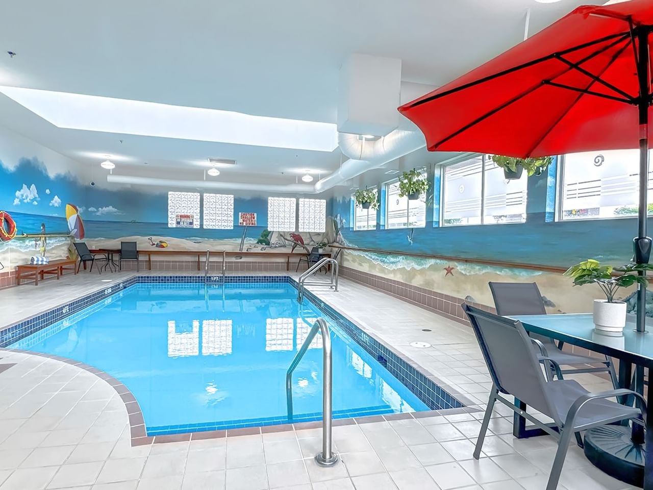 Hotel indoor pool with poolside table and umbrella