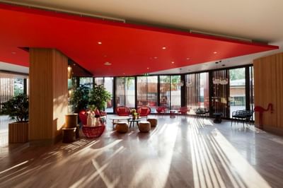 Lounge area with red cane chairs & wooden coffee tables at Eastin Hotels