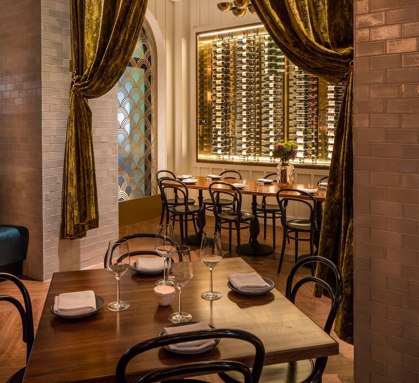 Private meeting room with tables and a lit wine display backdrop at Hotel Bijou, a stylish event space in San Francisco