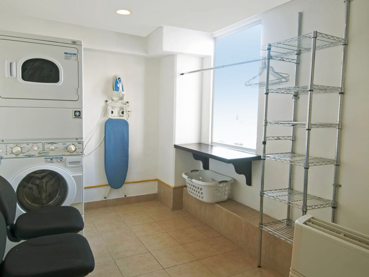 Laundry room with a washing machine & clothing rack, One Hotels