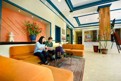 A couple sitting at the comfy couch at the lobby of the beach report - Lexis Port Dickson