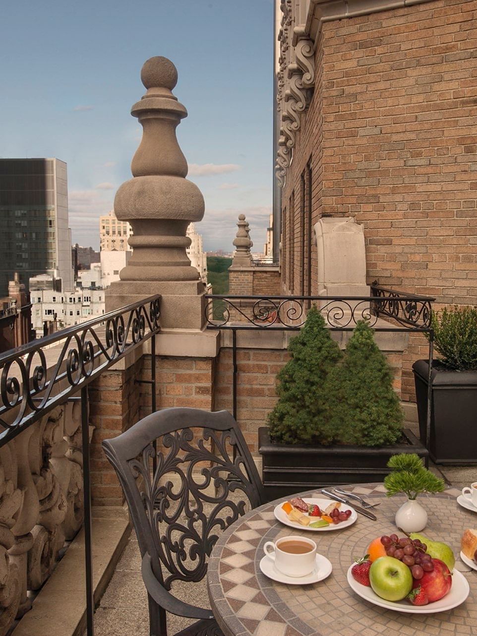 Suite of the Stars terrace dining set with fruit placed by coffee cups with the city skyline view at Warwick New York