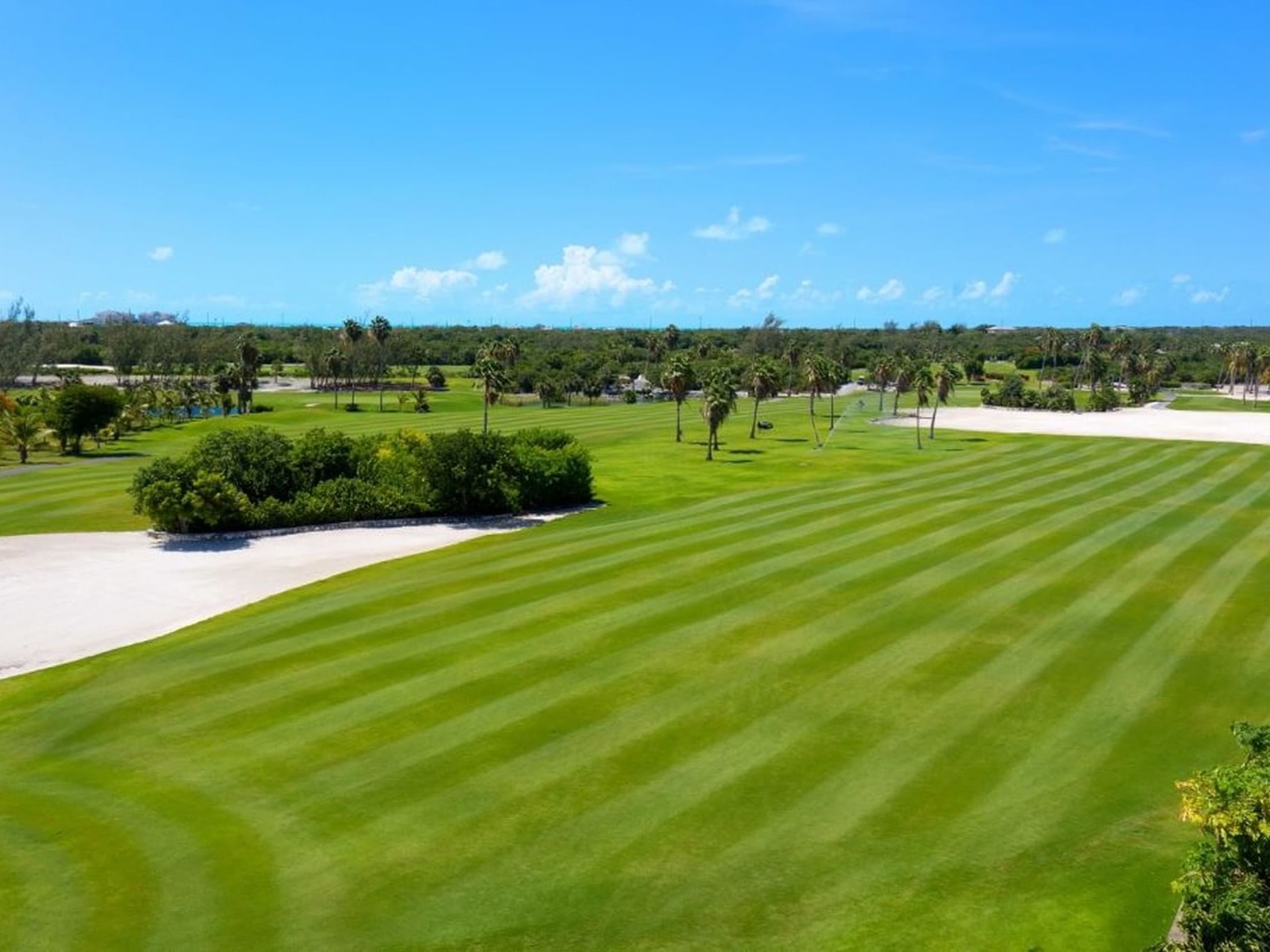 Aerial view of the vibrant lush greenery golf course near Windsong Resort On The Reef