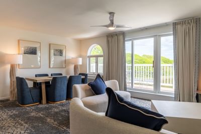 Living room with sofa, chairs, and large windows at a guest room at Ogunquit River Inn