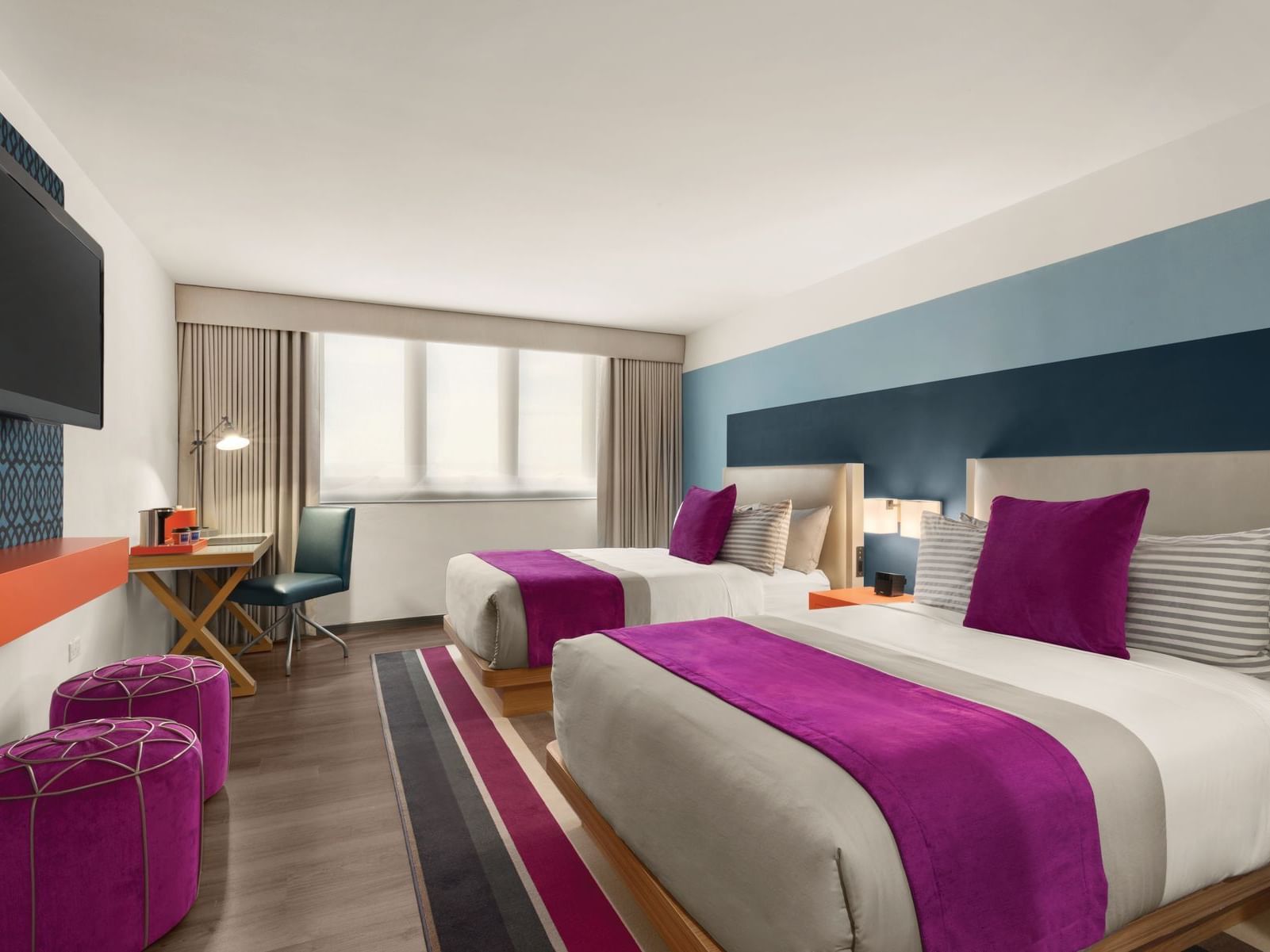 TRYP by Wyndham Isla Verde hotel room with two double beds, desk and television on wall