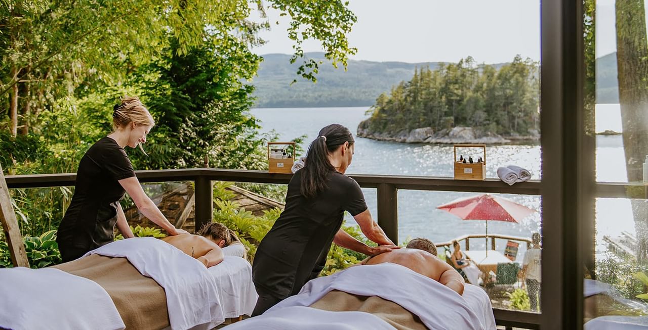 Two massage therapists giving massage