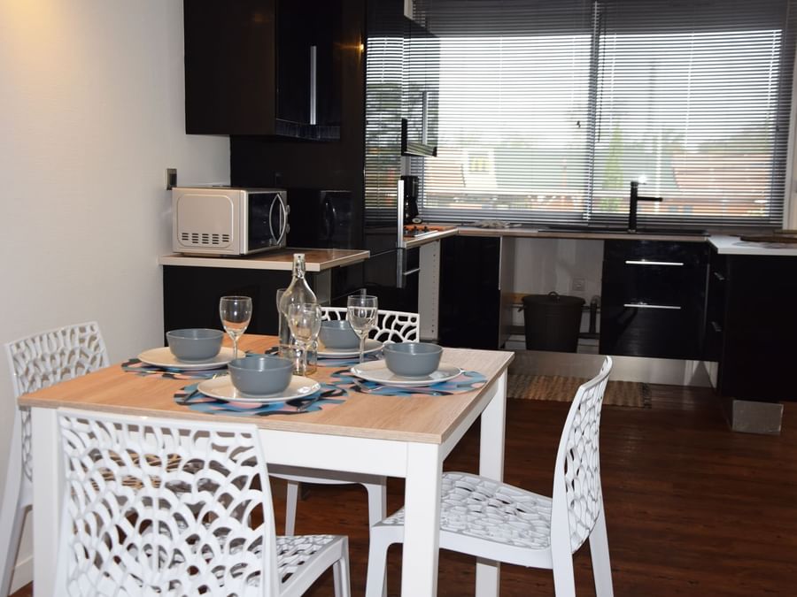 Kitchen and dining area in apartment at The Originals Hotels