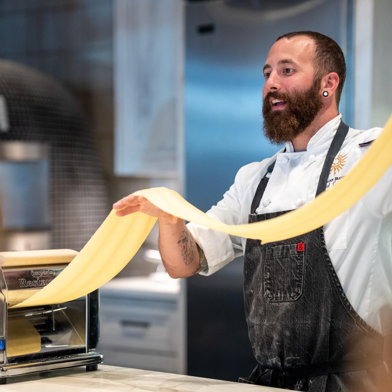 Chef Dave rolling a fresh pasta dough in a restaurant at The Artisan Hotel at Tuscan Village