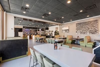 Interior of The Gavel at The Riverwalk Plaza Hotel featuring seating, a dining table, and a bar area with a decorative mural