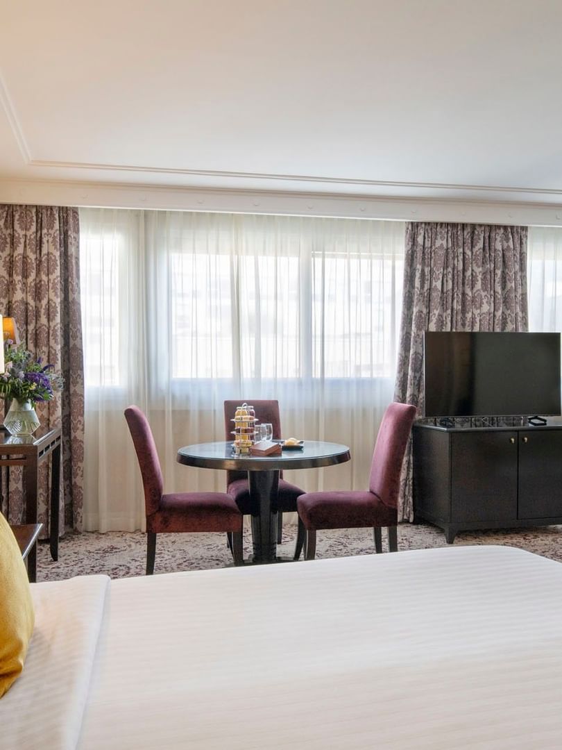 Une chambre Junior Suite à la décoration élégante et dotée d'un lit douillet au Warwick Champs-Élysées Paris.