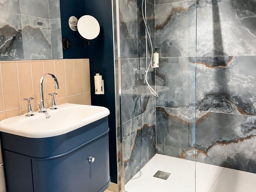 Salle de bain élégante avec douche et lavabo dans la Suite Junior à Osmo Hôtel, Chantepie