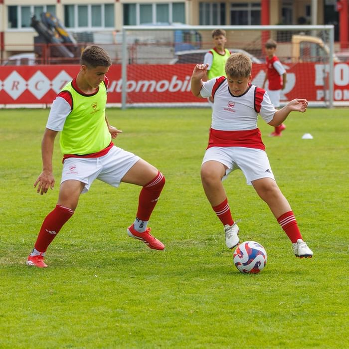 Dva dječaka igraju nogomet na travnjaku u Falkensteiner Resort Punta Skala.