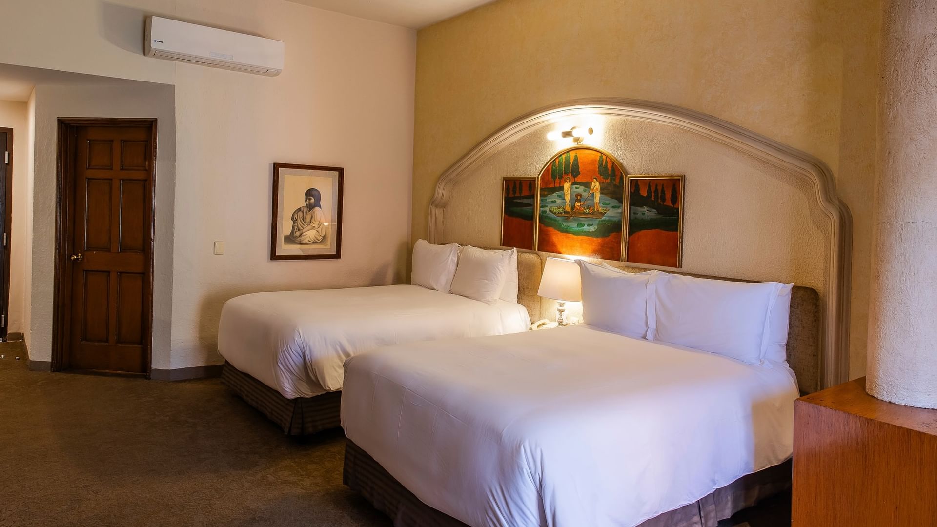 Suite con dos camas dobles, arco decorativo, arte colonial y aire acondicionado en Quinta Real Zacatecas