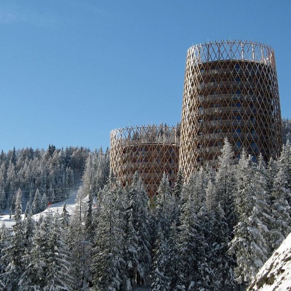Distance view of towers amidst snow-covered trees at Falkensteiner Residences edelweiss