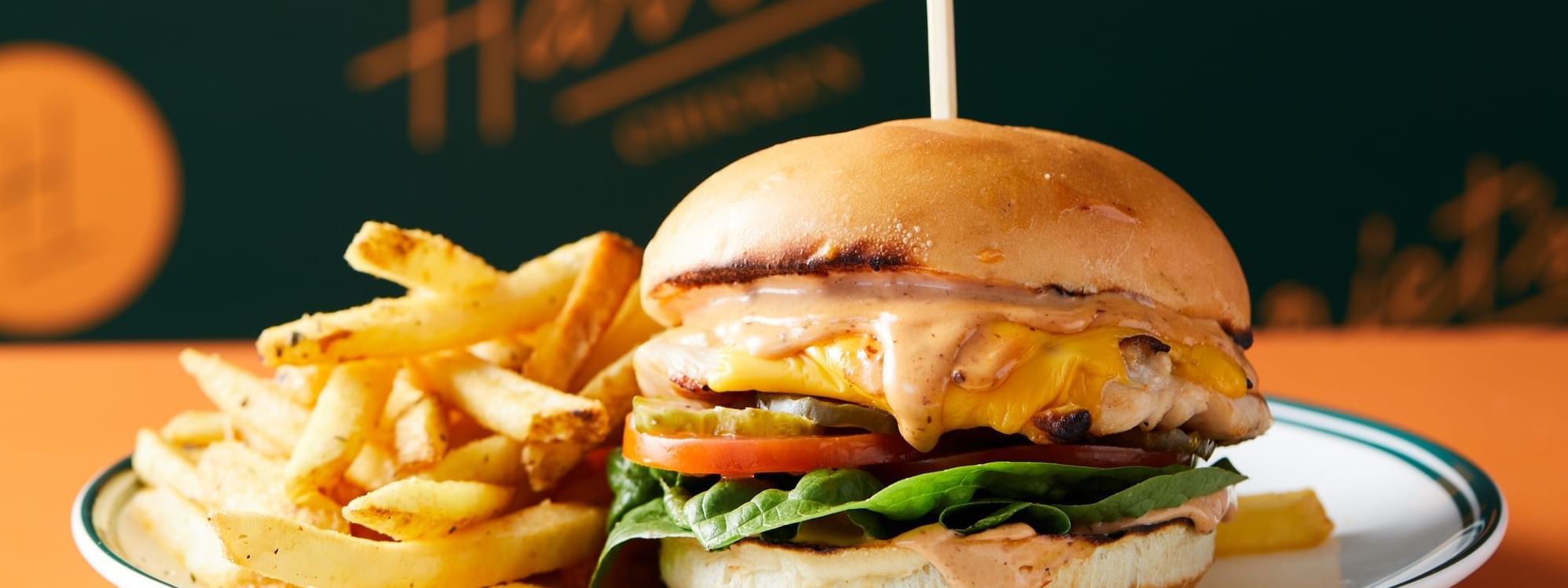 Delicious chicken burger with fries on a white plate, served at Harriet’s Chicken in Novotel Sydney
