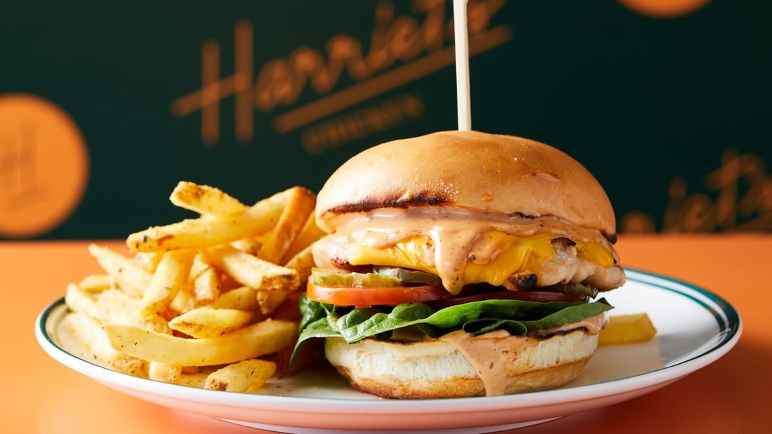Delicious chicken burger with fries on a white plate, served at Harriet’s Chicken in Novotel Sydney