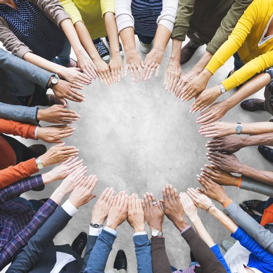 a group of people form their hands into a circle