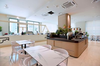 Table setup and counter with coffee machines and plants in Coffee House at Cititel Express Kota Kinabalu