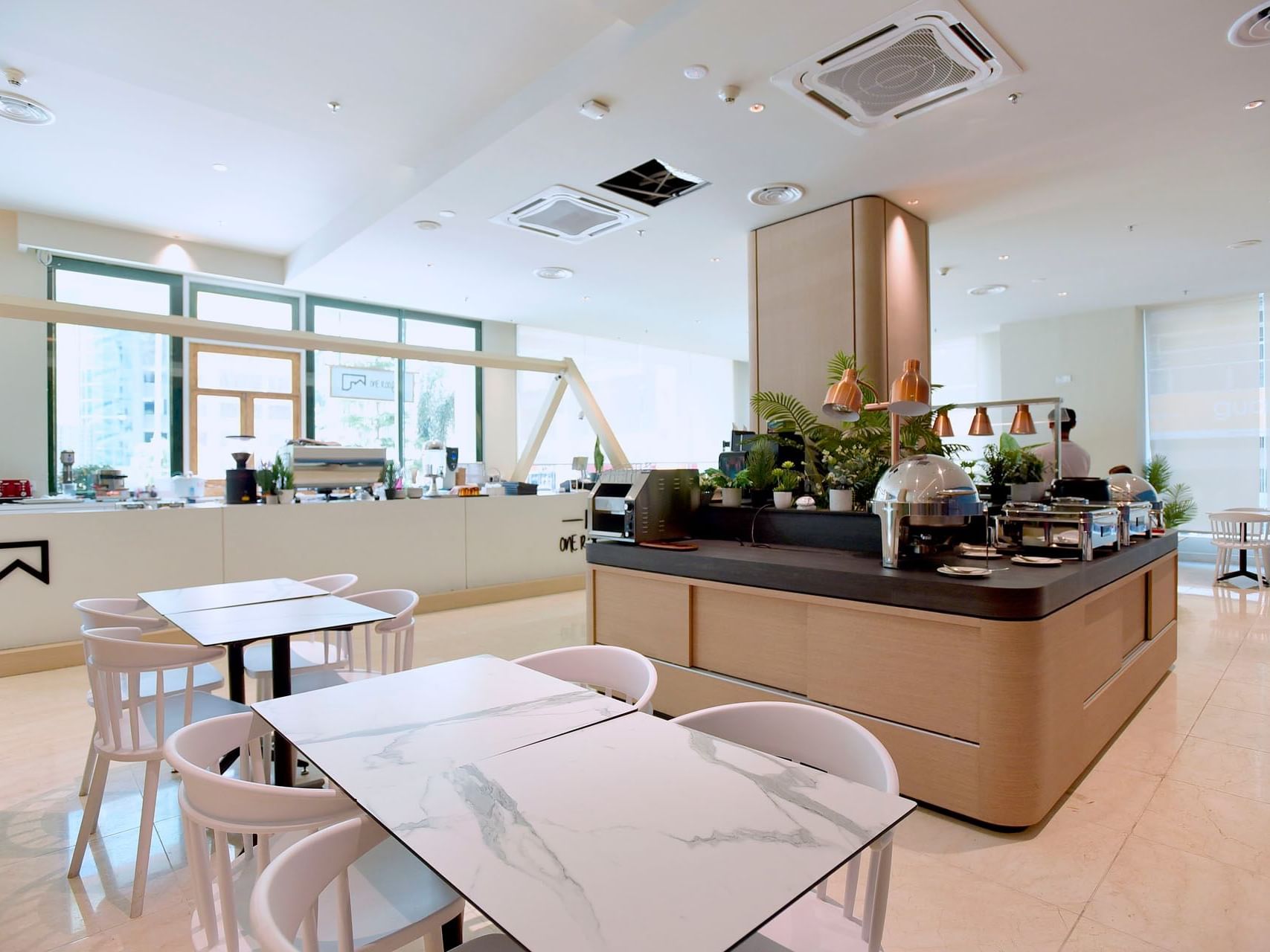 Table setup and counter with coffee machines and plants in Coffee House at Cititel Express Kota Kinabalu