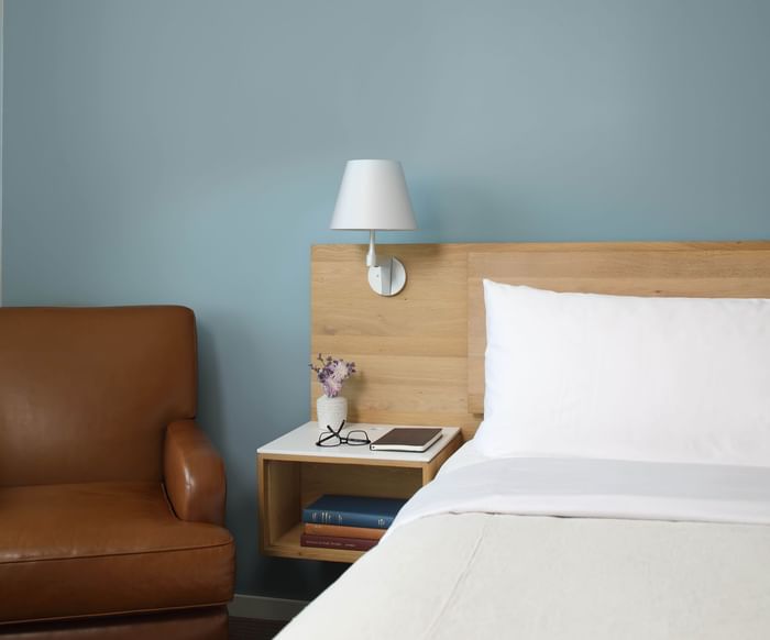 Leather armchair by the cozy bed in Philadelphia Suite at The Study at University City