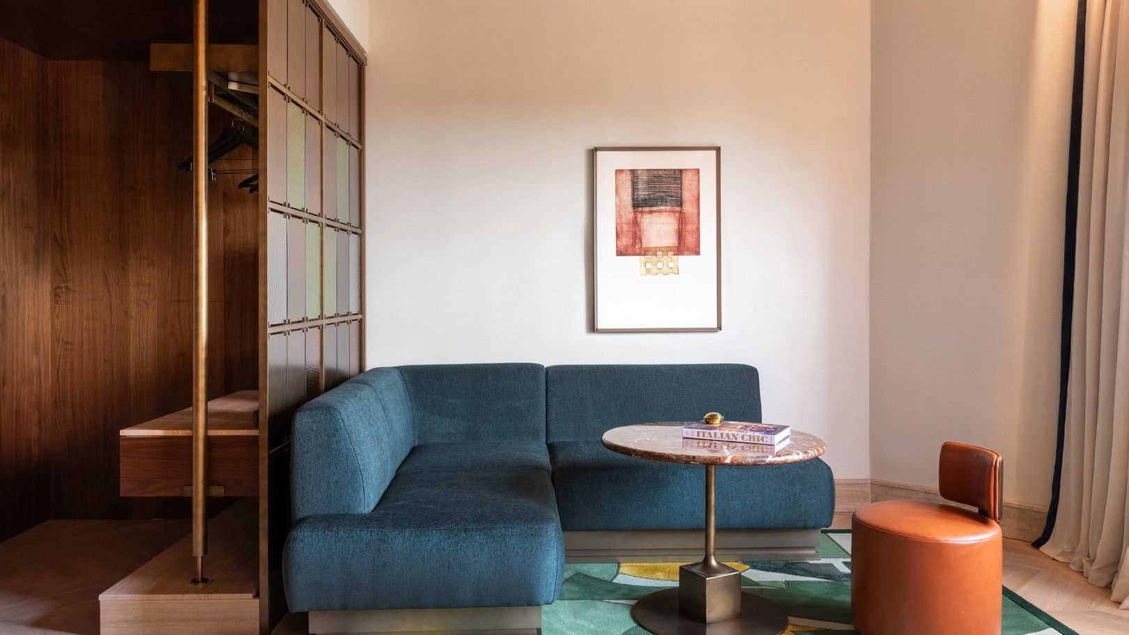 Modern 1 King Bed Suite living area with teal sofa, geometric rug, and framed artwork at The Thompson Rome, Roma.