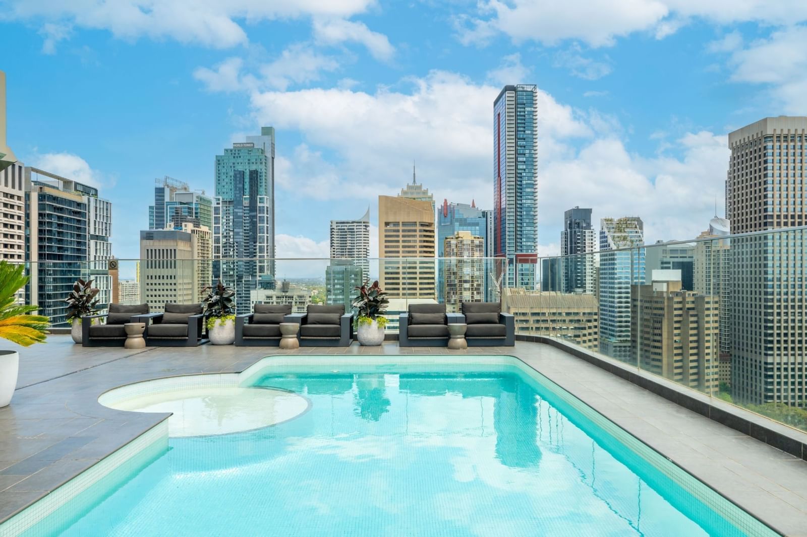 Rooftop pool area & loungers with a city view at Pullman Sydney Hyde Park